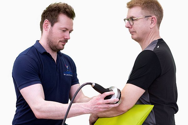 Stoßwellentherapie bei Tennisellenbogen bei einem Mann in der Praxis für Physikalische Medizin Innsbruck.